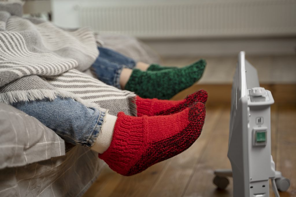 A feet of a couple enjoying an eco-friendly radiators warmth alone in a room