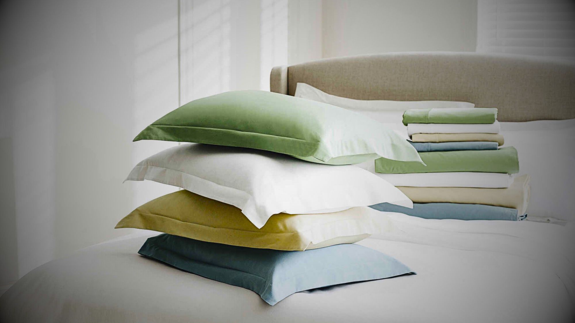 A neatly arranged stack of pillows showcasing the comfort of bedding materials