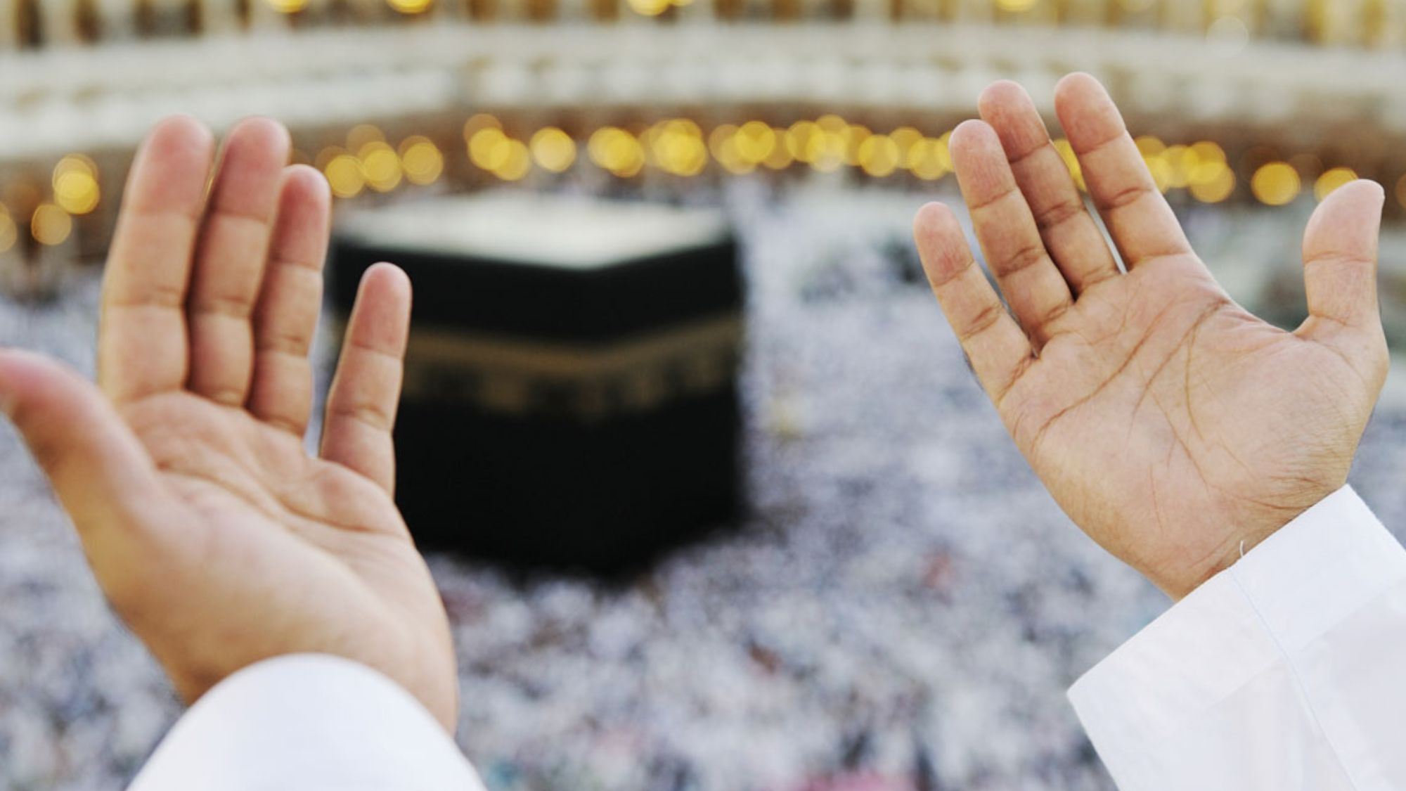 Muslim pilgrim praying in front of the kaaba during umrah journey