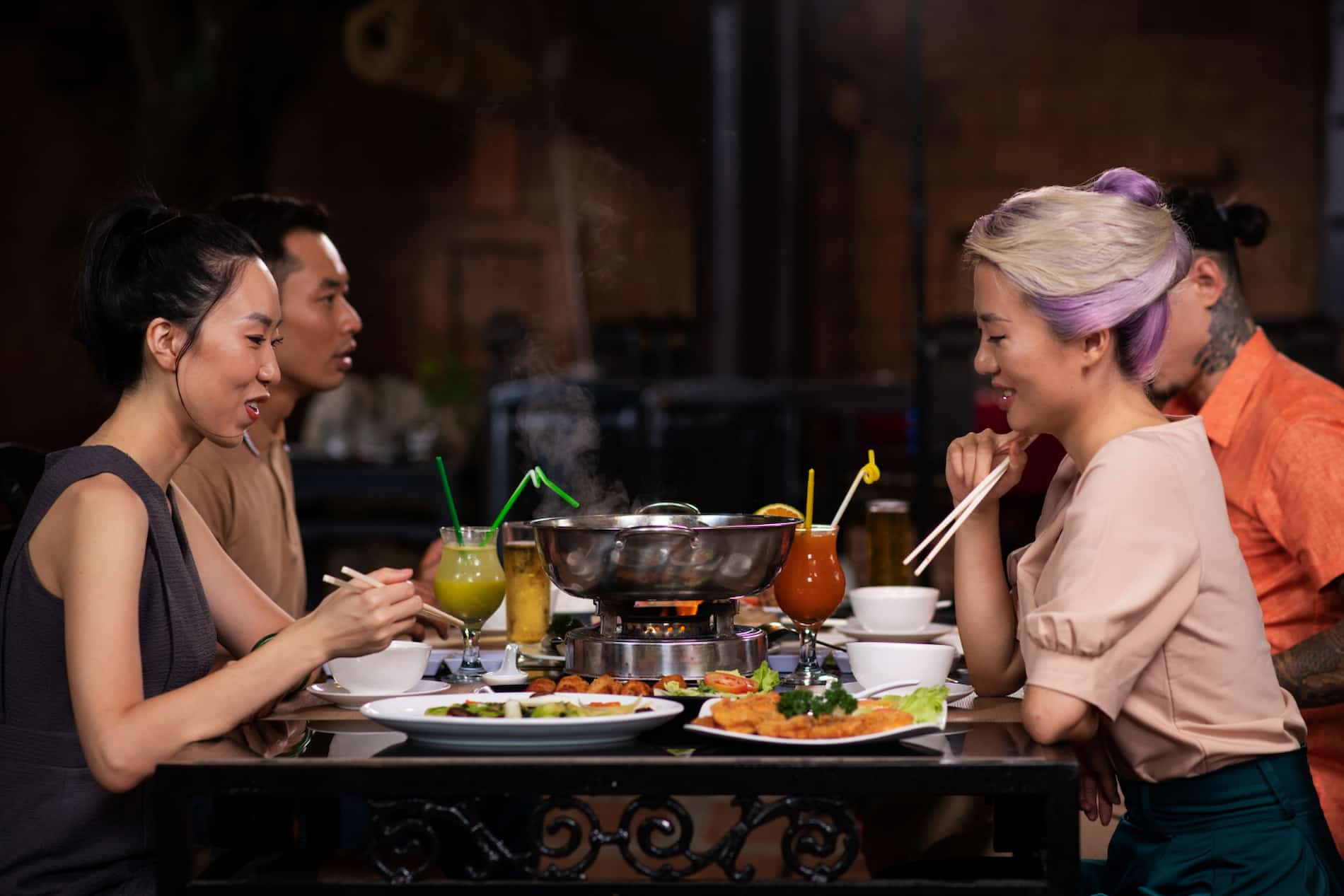 Asian people enjoying a meal at a restaurant, savoring diverse flavors from lesser-known Asian beverages.
